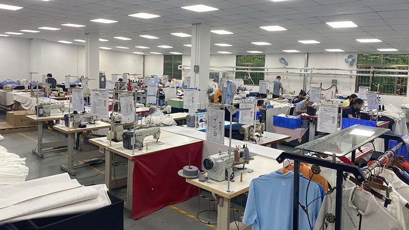 a golf apparel brand owner is reviewing fabric swatches with a manufacturer