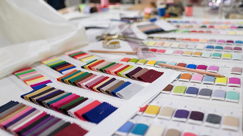 a close-up of custom details on a golf shirt, like a logoed button or zipper pull