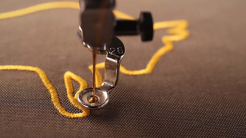 A polo shirt being secured in an embroidery hoop with backing material