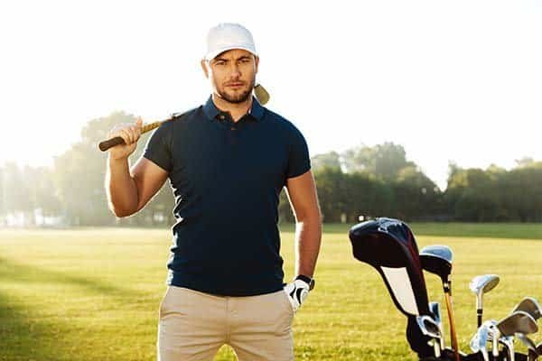 handsome,confident,male,golfer,standing,with,golf,club,on,a